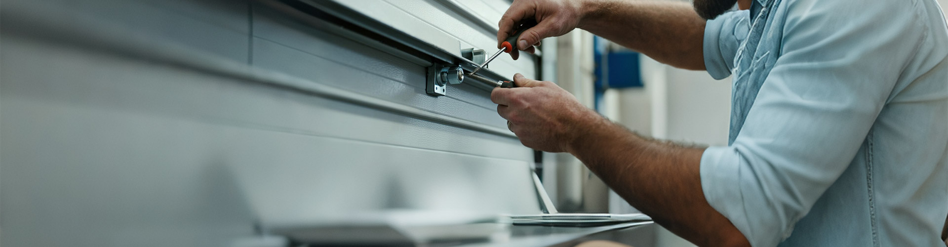 Garage Door Installation Tutorials Technician installing sectional garage door hardware